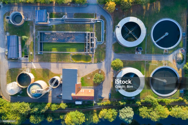 Aerial view of a small, local sewage treatment plant surrounded by forest